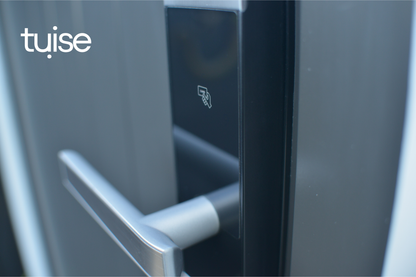 Close-up of a door handle with 'tuise' branding on a metallic surface.